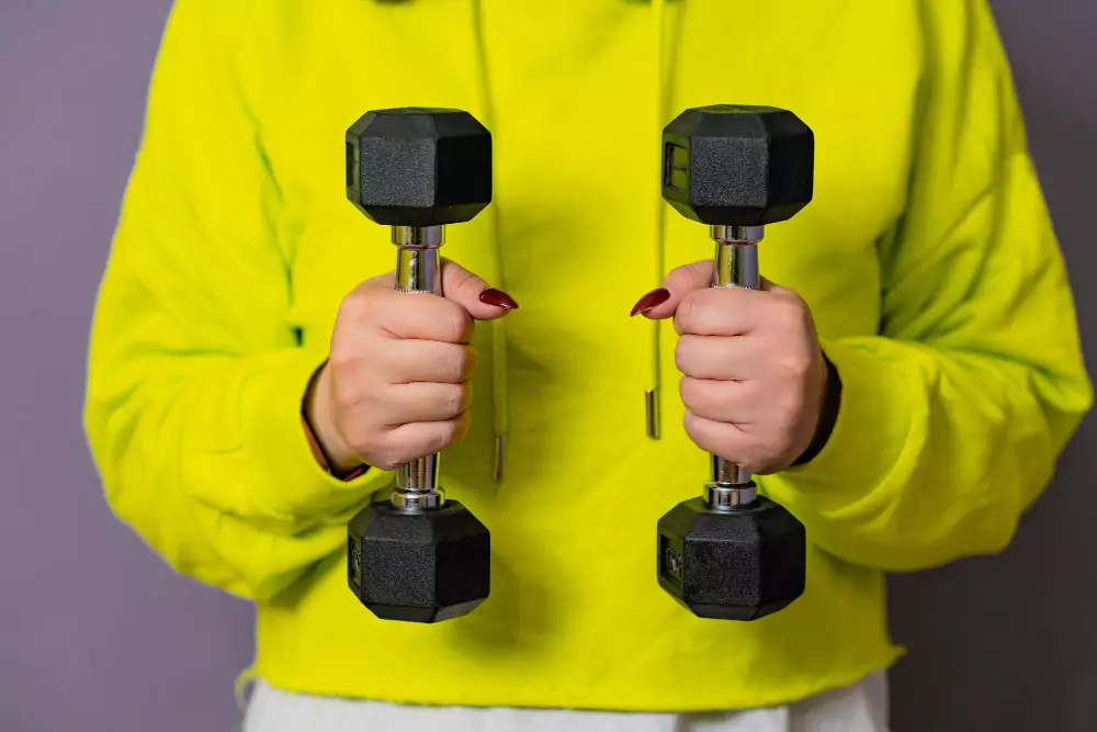 Person testing grip strength with dumbbells as a measure of longevity.